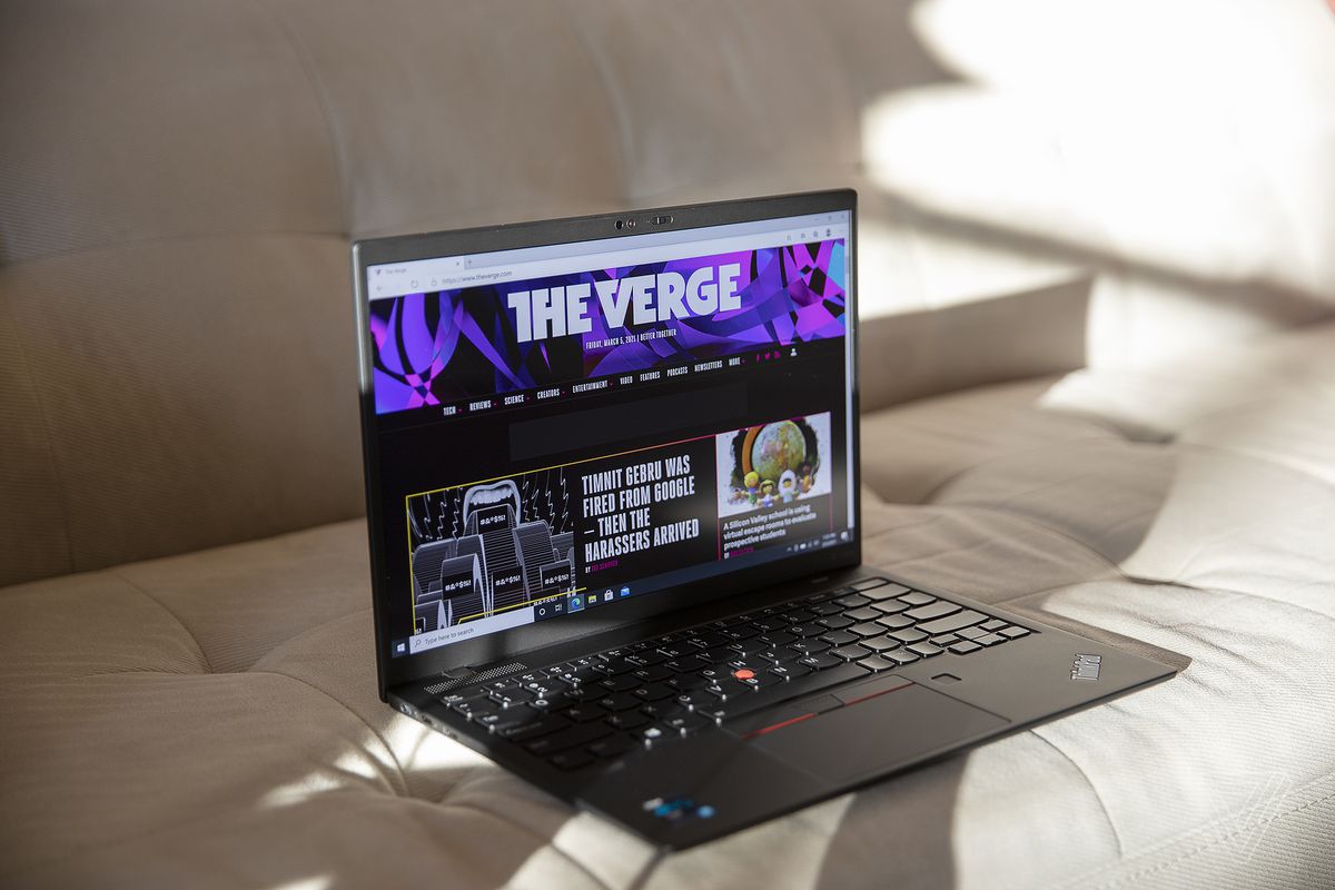 ThinkPad X1 Nano este așezat pe o canapea, înclinat ușor spre dreapta, deschis. Ecranul afișează pagina de pornire The Verge.