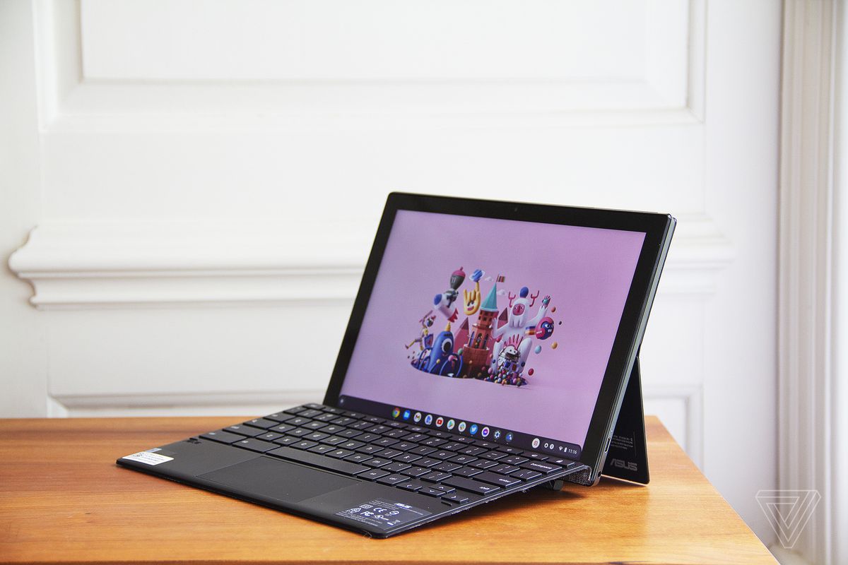 Asus Chromebook CM3 detașabil deschis, înclinat spre stânga.  Ecranul afișează o scenă de oraș cu desene animate pe un fundal roz.