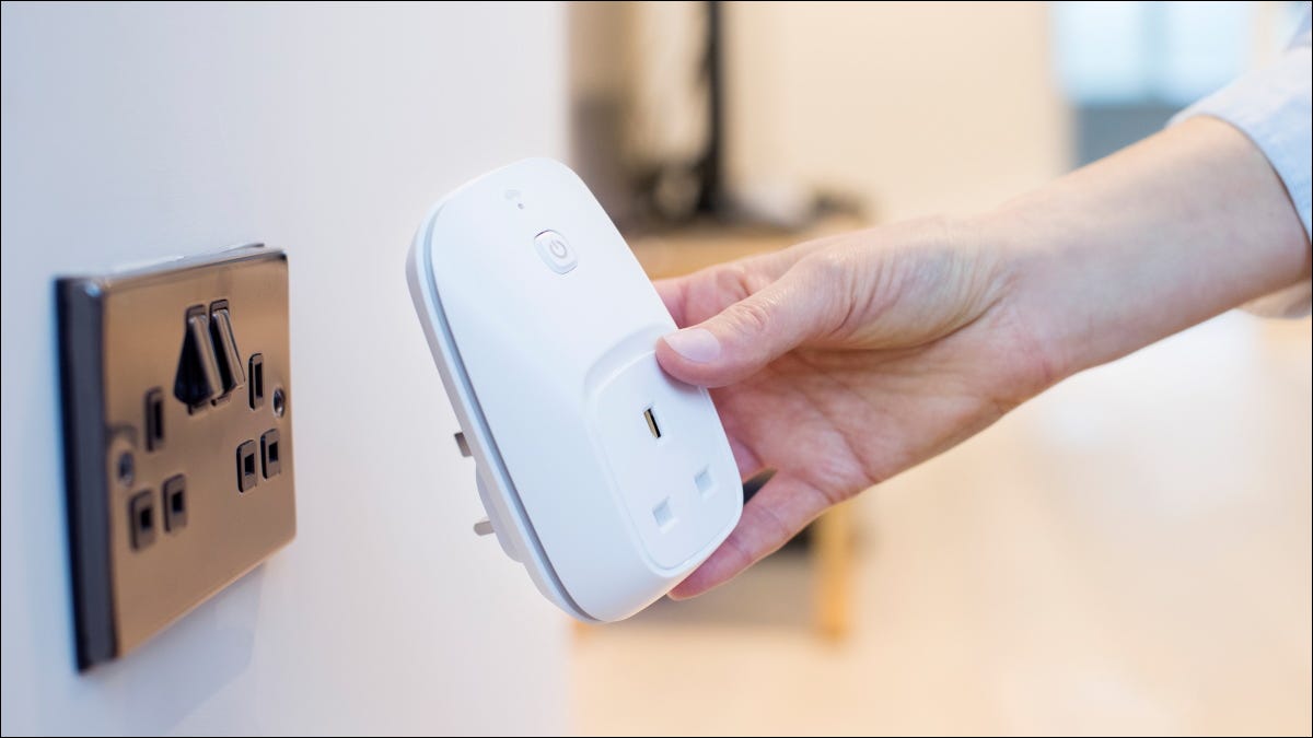 O femeie care conectează o priză inteligentă la o priză de perete.