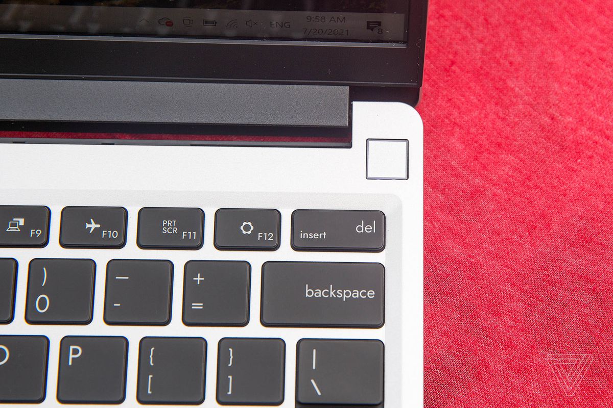 Senzorul de amprentă de pe laptop-ul Framework de pe o față de masă roșie.