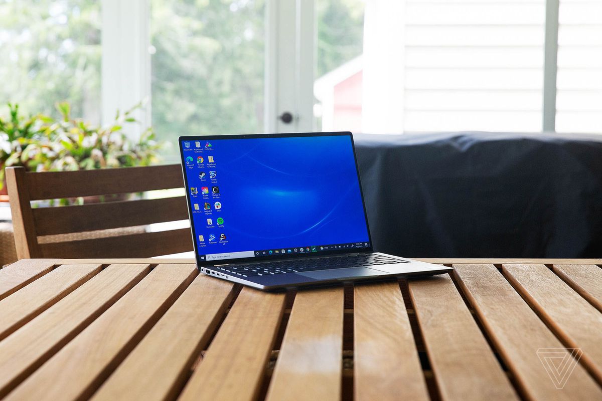 Dell Latitude 9420 pe o masă de lemn, deschisă, ușor înclinată spre dreapta.  Ecranul afișează un fundal albastru pentru desktop.