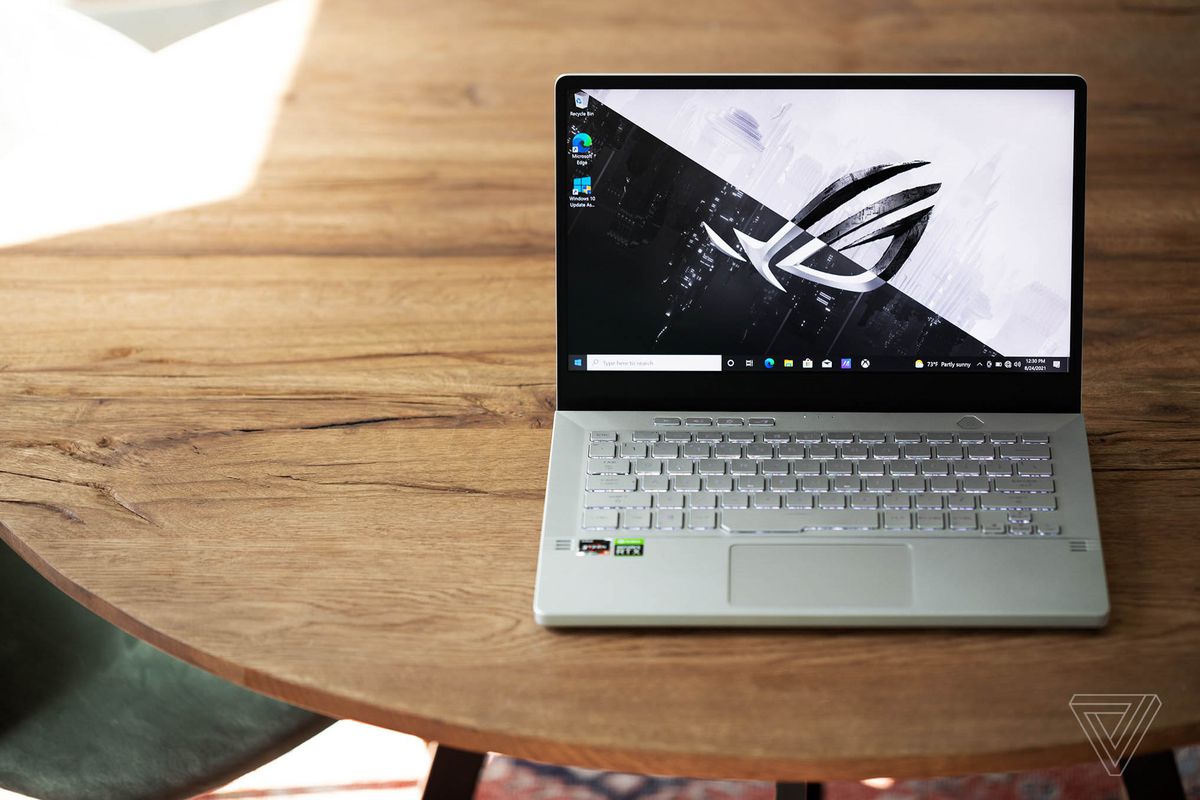 Zephyrus G14 se deschide pe o masă văzută de sus. Ecranul afișează sigla ROG pe un fundal alb-negru.