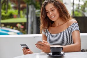 Avantajele unui card de cumpărături photo beautiful female tourist uses modern phone credit card booking ticket online 1